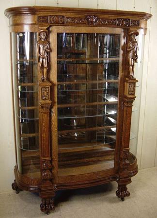 Oak Serpentine Glass China Cabinet with carved noblemen